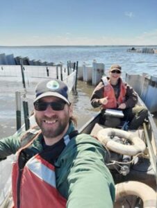 Two biologists in a canoe collecting data from a Mesocosm exclosure on Malheur Lake.